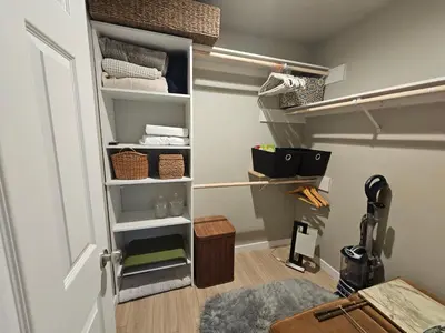 a walk in closet with shelves and a door at Beautiful new construction 1br with full size appliances centrally located in La Mesa