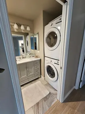 a bathroom with a washing machine and a sink at Beautiful new construction 1br with full size appliances centrally located in La Mesa