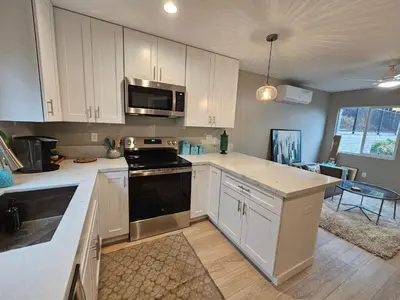 a kitchen with white cabinets and a stove top oven at Beautiful new construction 1br with full size appliances centrally located in La Mesa