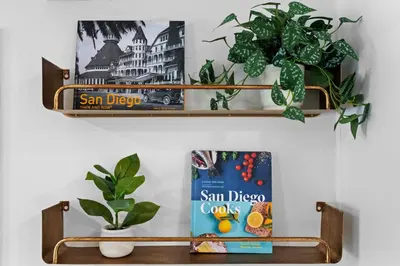 a shelf with a book and some plants on it at NEW! Hot TubPoolFire Pit10 Mins to Beach in San Diego