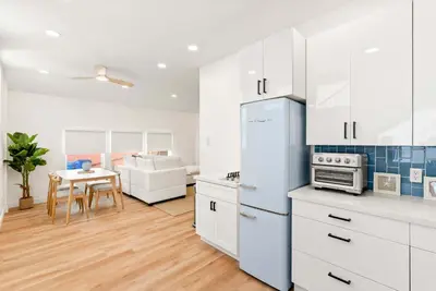 a kitchen with white cabinets and a table in a room at La Jolla Villa by the Sea - Walk to Windansea in San Diego