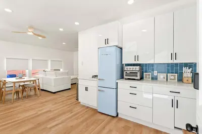 a kitchen with white cabinets and a blue refrigerator at La Jolla Villa by the Sea - Walk to Windansea in San Diego