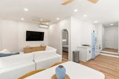 a living room with a white couch and a tv at La Jolla Villa by the Sea - Walk to Windansea in San Diego