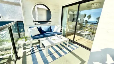 a living room with a couch and a table on a balcony at Location! Location! Location! Walk Everywhere! in Oceanside