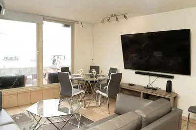 a living room with a couch and a table with chairs at Ocean Front On Beach! -2 Master BR, 2 Full BA, Patio!, AC, Parking, Close to All in San Diego