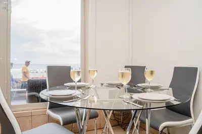 a glass table with chairs and wine glasses at Ocean Front On Beach! -2 Master BR, 2 Full BA, Patio!, AC, Parking, Close to All in San Diego