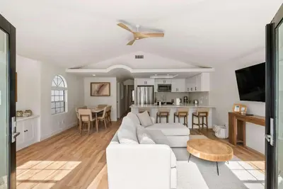 a living room with a white couch and a table at Luxury La Jolla Beach Retreat - Steps to Windansea in San Diego