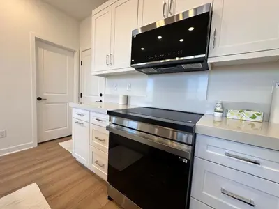 a kitchen with white cabinets and a black stove top oven at 4 Bed Large House in San Diego Amazing Amenities in Chula Vista