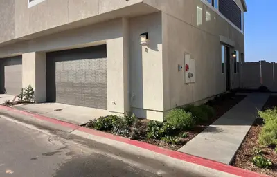 a building with a garage door next to a street at 4 Bed Large House in San Diego Amazing Amenities in Chula Vista