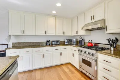 a kitchen with white cabinets and stainless steel appliances at Walk to Mission Beach! Gem with Bay and City Views in San Diego