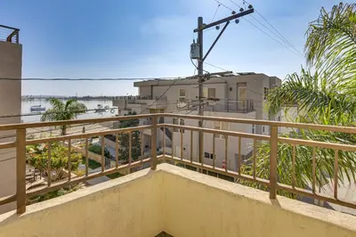 a balcony with wooden railing and a view of the water at Walk to Mission Beach! Gem with Bay and City Views in San Diego