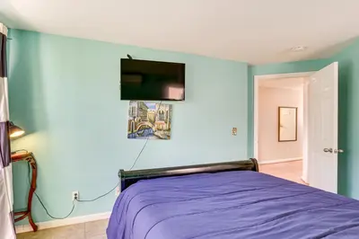 a bedroom with a bed and a tv on the wall at Walk to Mission Beach! Gem with Bay and City Views in San Diego