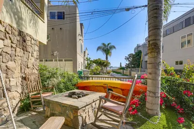 a table and chairs and a surfboard in a yard at Walk to Mission Beach! Gem with Bay and City Views in San Diego