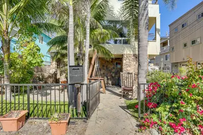 a resort with palm trees and a fence and flowers at Walk to Mission Beach! Gem with Bay and City Views in San Diego