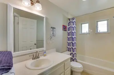 a bathroom with a sink and a toilet and a mirror at Walk to Mission Beach! Gem with Bay and City Views in San Diego