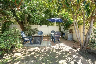 a patio with two chairs and a table with an umbrella at La Jolla Village Escape - Walk to Everything in San Diego