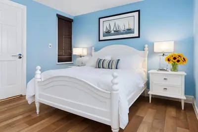 a bedroom with a white bed and blue walls at Newport Beach Oceanside Stay in Newport Beach