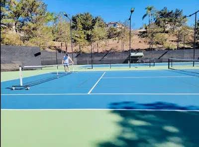 a person playing tennis on a tennis court at Newly Built Coastal Southern California Getaway in Carlsbad