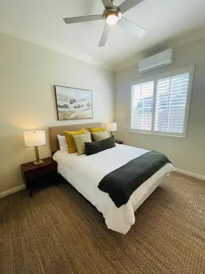 a bedroom with a large bed with a ceiling fan at Newly Built Coastal Southern California Getaway in Carlsbad