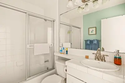 a white bathroom with a sink and a shower at Bayfront Bliss in San Diego
