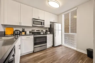 a kitchen with white cabinets and a refrigerator at Luxury 2BR Apartment Near SeaWorld, Airport & Downtown San Diego in San Diego