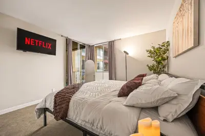 a large bed in a room with a sign on the wall at Luxury 2BR Apartment Near SeaWorld, Airport & Downtown San Diego in San Diego