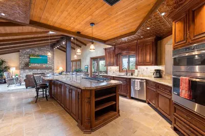 a large kitchen with wooden cabinets and a large island at Tuscan Views with Country Vibes in Bonsall