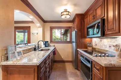 a kitchen with wooden cabinets and granite counter tops at Tuscan Views with Country Vibes in Bonsall