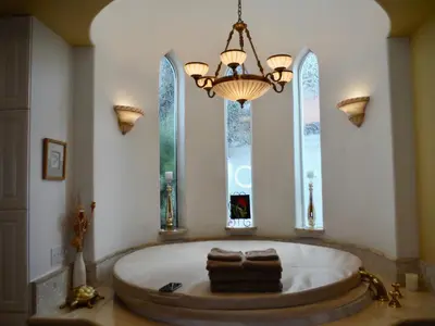a large bathroom with a large tub with windows at Bella Vita Gated Resort in Escondido