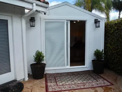 a sliding glass door with two potted plants on a patio at Bella Vita Gated Resort in Escondido