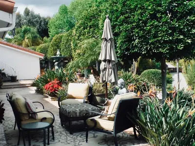 an outdoor patio with chairs and an umbrella at Bella Vita Gated Resort in Escondido