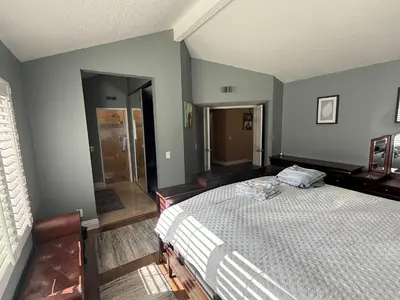 a bedroom with a bed and a walk in shower at South OC House in Laguna Niguel