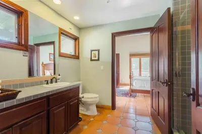 a bathroom with a toilet and a sink and a mirror at Fallbrook Vineyard Estate in Fallbrook
