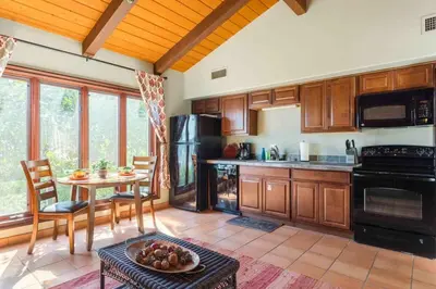 a kitchen with wooden cabinets and a table with a bowl of fruit at Fallbrook Vineyard Estate in Fallbrook