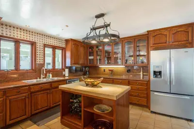 a kitchen with wooden cabinets and a white refrigerator at Fallbrook Vineyard Estate in Fallbrook