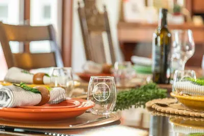 a table with glasses and plates and a bottle of wine at Fallbrook Vineyard Estate in Fallbrook