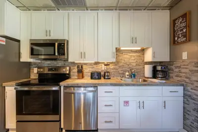 a kitchen with white cabinets and a stainless steel appliance at Man Cave and She Shed in Fallbrook