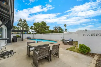 a patio with a table and chairs and a swimming pool at VaCaTiOn Pool FirePit PoolTable CloseToFwy in Mission Viejo