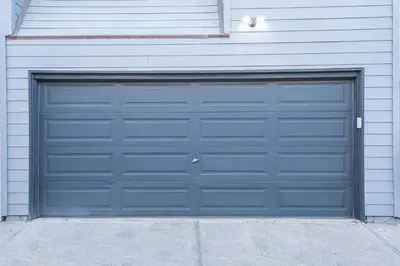 a blue garage door on a white building at Charming 6Br Retreat With Oceanview Patio, Steps From Sand By Beachview Rentals in Newport Beach