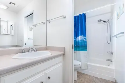 a white bathroom with a sink and a toilet at Charming 6Br Retreat With Oceanview Patio, Steps From Sand By Beachview Rentals in Newport Beach
