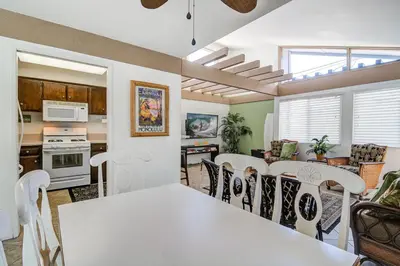 a kitchen and dining room with a white table and chairs at Charming 6Br Retreat With Oceanview Patio, Steps From Sand By Beachview Rentals in Newport Beach