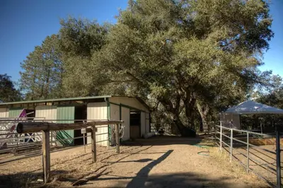 a building with a tree and a fence at Boutique Nature Retreat in the Palomar Mountains in Pauma Valley