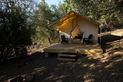a tent with a table and chairs in a field at Boutique Nature Retreat in the Palomar Mountains in Pauma Valley