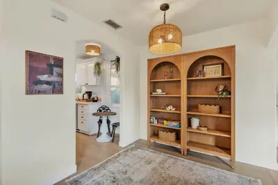 a living room with a large wooden book shelf at Newly Furnished 3BR 1BA - Spa - AC - Large Backyard in San Diego