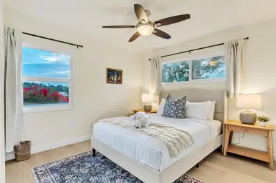 a white bedroom with a bed and two windows at Newly Furnished 3BR 1BA - Spa - AC - Large Backyard in San Diego