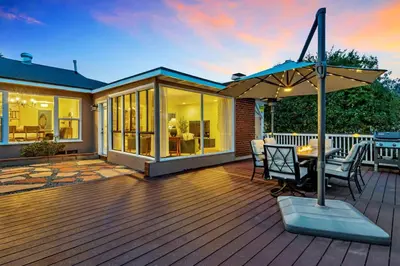 a wooden deck with a table and an umbrella at Newly Furnished 3BR 1BA - Spa - AC - Large Backyard in San Diego