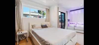 a white bedroom with a large bed and a window at Mission Beach Suite Parking Steps 2 Ocean in San Diego