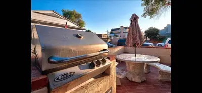 a grill on a patio with a table and a umbrella at Mission Beach Suite Parking Steps 2 Ocean in San Diego