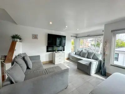 a living room with a couch and a flat screen tv at Mission Beach Loft Garage Steps 2 Ocean in San Diego