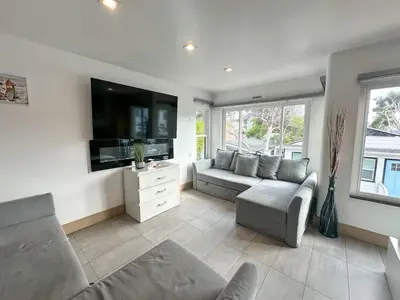a living room with a couch and a flat screen tv at Mission Beach Loft Garage Steps 2 Ocean in San Diego